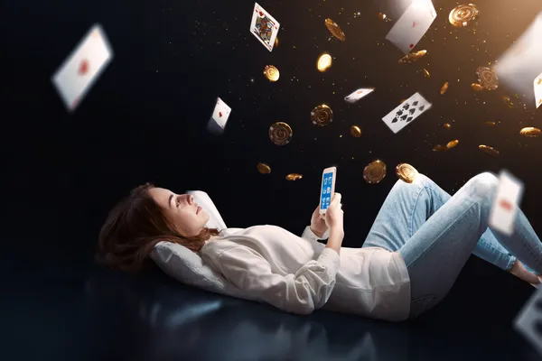 A young woman relaxing with her phone while dynamic casino elements float around her, illustrating the smooth mobile experience offered by the WAGIPLUS app.