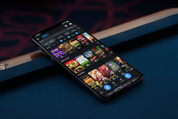 A young woman relaxing with her phone while dynamic casino elements float around her, illustrating the smooth mobile experience offered by the WAGIPLUS app.