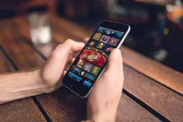 A cheerful woman in traditional clothing using her smartphone during a festive moment, showing how easily the WAGIPLUS app fits into everyday life.