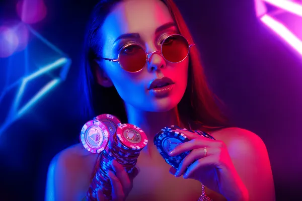 A glamorous woman holding casino chips in a neon-lit environment, representing the premium online casino atmosphere of WAGIPLUS.