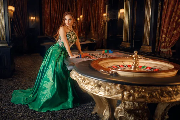 A woman in a luxurious green gown next to an ornate roulette wheel, capturing the upscale casino mood of WAGIPLUS.