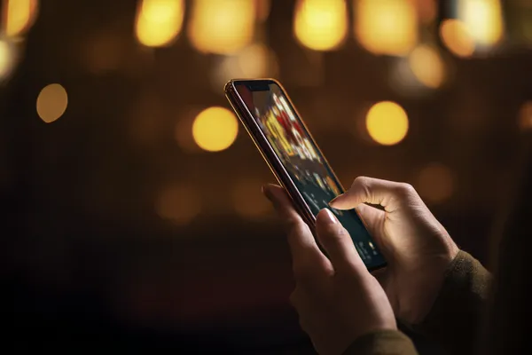 WAGIPLUS Slots — Thousands of thrilling machines await A woman smiling by bright slot machines showing lucky symbols, showcasing the exciting slot offerings at WAGIPLUS.