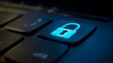 A laptop glowing with a bright login prompt in a minimalistic setup, symbolizing the protected access system at WAGIPLUS.